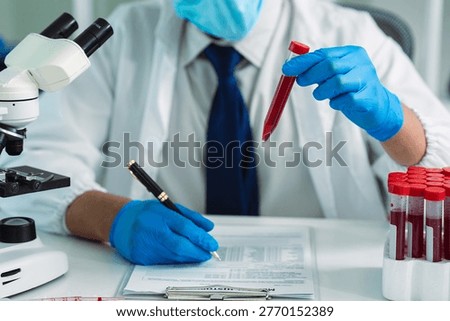 Scientists are analyzing blood samples in a laboratory related to medical research and development, blood analysis, and biotechnology.