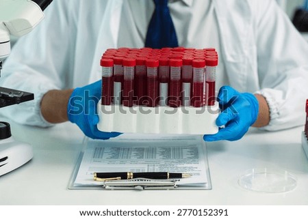Scientists are analyzing blood samples in a laboratory related to medical research and development, blood analysis, and biotechnology.