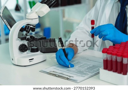 Scientists are analyzing blood samples in a laboratory related to medical research and development, blood analysis, and biotechnology.