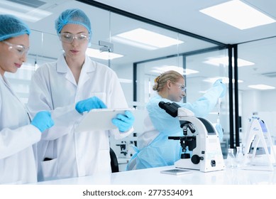 scientists collaborate on assay development, with one performing a critical pipetting step while the other documents the procedure on a tablet for protocol validation under GxP guidelines.