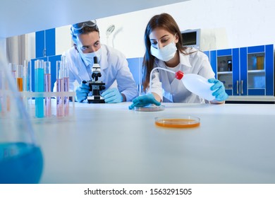 Scientists doing research and analysis with microscope in laboratory
