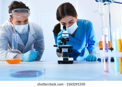 Scientists doing research and analysis with microscope in laboratory