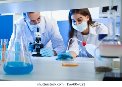 Scientists doing research and analysis with microscope in laboratory