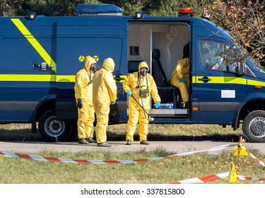 Scientists Dosimetrists In Protective Clothing, Gas Masks And Geiger Counter Near First Response Emergency Bus With Mobile Laboratory In Dangerous Radioactive Zone, Sofia, Bulgaria, November 6, 2015.