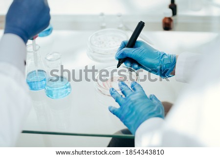 Scientists of the laboratory testing of microbial contamination in Petri plates.