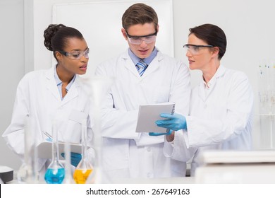 Scientists looking at clipboard in laboratory - Powered by Shutterstock