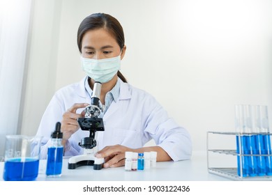 scientists researching in laboratory in white lab coat, gloves analysing, looking at test tubes sample, biotechnology concept.