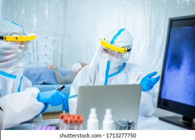 Scientists Studying Xray Of Coronavirus Patient Lung On Computer Screen With The Isolation Gown Or Protective Suits And Surgical Face Masks