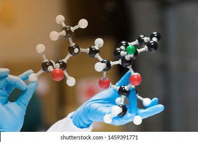 Scientists wear blue gloves hold the  molecular structure model will provide 3D arrangement of the atoms at chemistry laboratory for drug design - Powered by Shutterstock