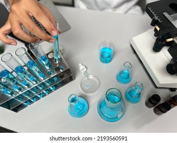 Scientists Wearing Gowns Conducted In Vitro Study Of Subjects ,side  Effects ,efficacy Of Drugs And Vaccines. Use A Microscope To Look Through The Slides. Let The Chemical Drop Into The Device