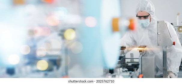 Scientists Wearing Protective Clothing Inspect Mask Making Machines In A Laboratory At An Industrial Plant. Anti-virus Production Warehouse. Concept Of Safety And Prevention Coronavirus Covid-19.