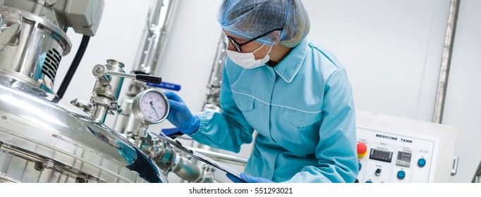 Scientists working with large vat in the lab, panoramic photo


