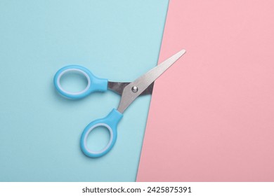 Scissors for creativity on a blue-pink background