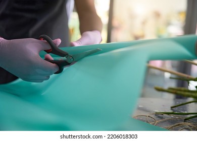 Scissors cut colored wrapping paper on the table - Shutterstock ID 2206018303