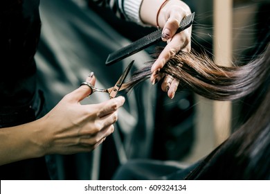 Scissors cut the girls hair, brunette - Shutterstock ID 609324134