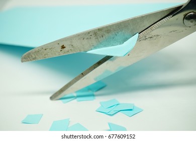 Scissors cut the paper into small pieces