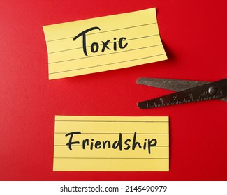 Scissors Cutting Note Paper With Handwritten TOXIC FRIENDSHIP, Refers To Friends Who Leave Negative Effects - Mentally Energy Drain And Bring Down Emotionally