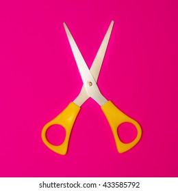 Scissors Cutting On Pink Paper Background