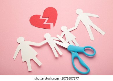 Scissors Cutting Paper Cut Of Family On Pink Background. Broken Family Concept, Divorce. Top View