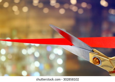 Scissors cutting red ribbon