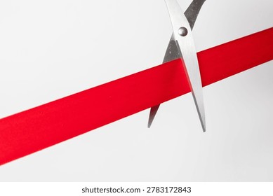 scissors cutting a red ribbon on clean background, symbolizing business launch, grand opening, success, achievement, and new beginnings in corporate or startup concept.