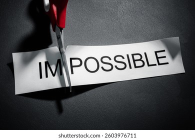 Scissors cutting the word impossible to make possible concept for self belief, positive attitude and motivation