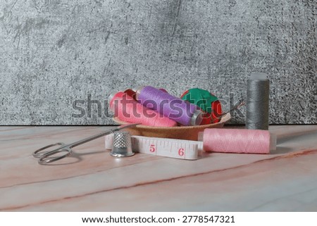 scissors, embroidery needle, colored threads, thimble