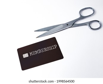 Scissors next to a membership card. Concept for cutting the costs, cancellation, termination of subscription and membership. Copy space on the card and the image.