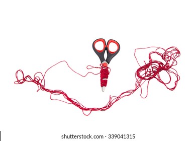 Scissors and red thread  on white background. Isolated photo of an object with white background.