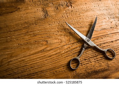 Scissors Sits Half Open On A Worn Butcher Block Counter Top. Vintage Aged Used Scissors Lie On Aged Wooden Table Background. Texture Backdrop. Empty Copy Space For Inscription Or Other Objects. 