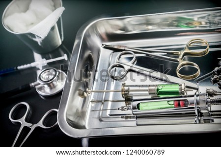 scissors and syringes on a table of operating theater of a hospital conceptual image