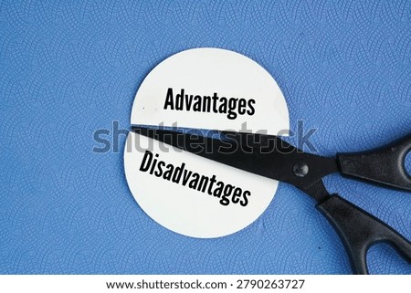 Scissors and two pieces of paper are separated by different words Disadvantage and Advantages. the positive and negative aspects of a choice, situation, or tool. Advantages provide a benefit, gain