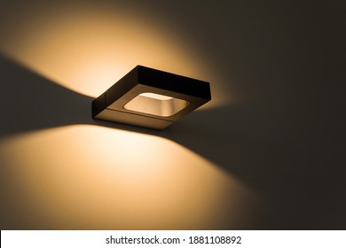 Sconce. Modern Minimalist Black Square Wall Lamp Shines With Yellow Light. Internal Lighting. Close-up. Beautiful Geometric Shadows.