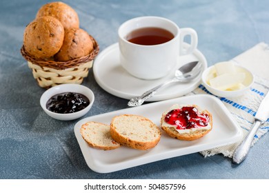 Scones with butter and jam with tea on the table - Shutterstock ID 504857596