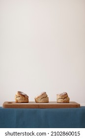 Scones - homemade sweet scones on the bread board, side view on the white background