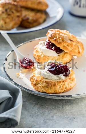 Scones with jam and tea with milk close-up on the table