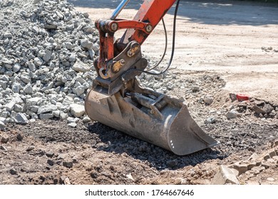 Scoop From A Digger Resting On The Ground Amongst Rubble.