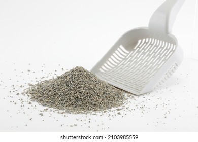 Scoop and heap of cat litter isolated on white