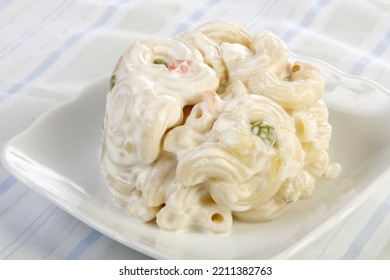 A Scoop Of Macaroni Salad With Peas And Carrots