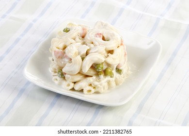 A Scoop Of Macaroni Salad With Peas And Carrots