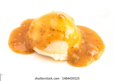A Scoop of Mashed Potatoes with Brown Meat Gravy on Top Isolated on a White Background