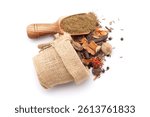 A scoop of organic warming spices or whole Garam Masala powder, along with whole spices spilled out from a jute bag. Isolated on a white background.