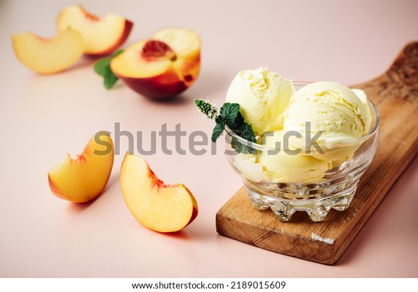 Scoop of peach ice cream\
in a glass.