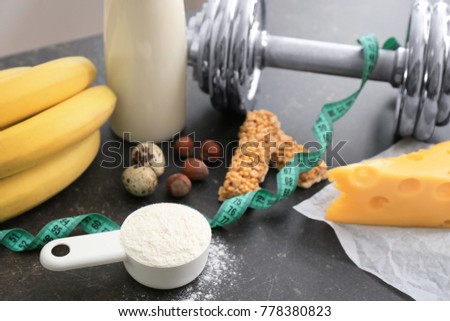 Scoop with protein powder and products on table