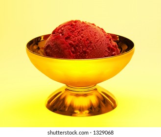 A Scoop Of Rasberry Sorbet In A Golden Setting.