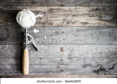 Scoop of vanilla ice-cream on rustic wooden background