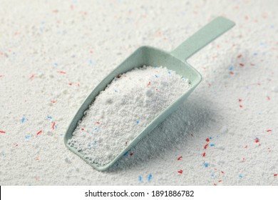 Scoop with washing powder on washing powder background