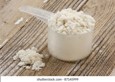 A Scoop Of Whey Protein Isolate Powder On A Grunge Wooden Table Background