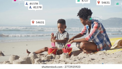 Scooping boy between red buckets, woman in plaid shirt kneeling at shore with pink shovel, overlays. Beach, sand, parent, child, outdoors, sunshine, playful
