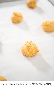 Scooping dough with dough scoop to bake eggnog scones.